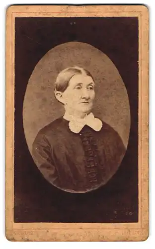 Fotografie G. Zwang, Leipzig, Kl. Fleischergasse 13, Gestandene Frau mit Hochsteckfrisur im zweifarbigen Rüschenkleid