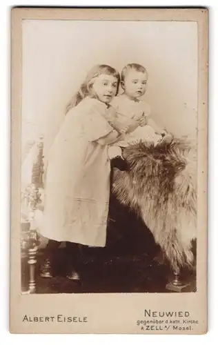 Fotografie Albert Eisele, Neuwied, Marktstrasse 43, Mädchen mit Ponyfrisur, ein Kleinkind auf einem Fell festhaltend