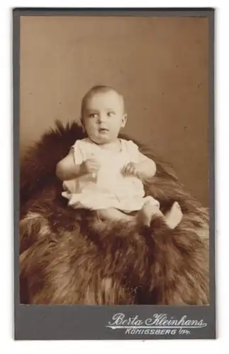 Fotografie Berta Klainhans, Königsberg, Baby im Strampelkleid auf einem Fell