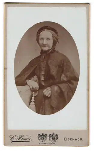 Fotografie Carl Remde, Eisenach, Frauenberg 29, Alte Frau mit eingefallenem Mund in einem Kleid mit Umhang