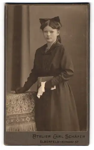 Fotografie Carl Schäfer, Elberfeld, Kipdorf 57, Konfirmandin mit Haarschleife, Handschuhen, Taschentuch und Gesangbuch