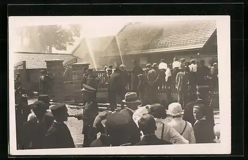 Foto-AK Feuerwehrleute löschen ein brennendes Haus