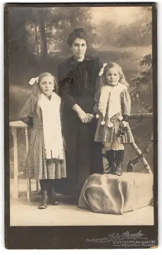 Fotografie Gebr. Strauss, Stuttgart, Königstr. 82, Mutter mit niedlichen Töchtern im karierten Kleid