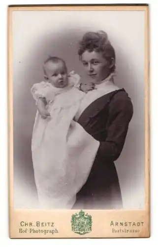 Fotografie Chr. Beitz, Arnstadt, Poststr., junge Mutter hält Baby im Taufkleid