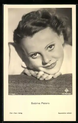 AK Schauspielerin Sabine Peters lächelnd mit dem Kopf auf einer Lehne liegend