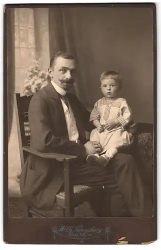 Fotografie Wilhelm Tanneberg, Genthin, stolzer Vater mit Sohn auf dem Schoss