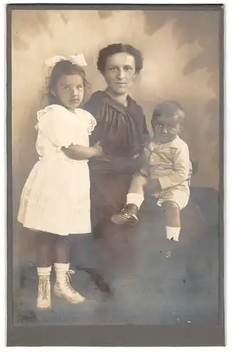 Fotografie unbekannter Fotograf und Ort, Mutter nebst Tochter im weissen Kleid & Sohn auf dem Schoss sitzend
