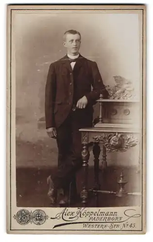 Fotografie Alex Köppelmann, Paderborn, Westernstrasse 45, Junger Mann in lässiger Pose an einen Sekretär lehnend