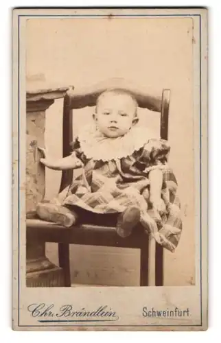 Fotografie Chr. Brändlein, Schweinfurt, Kleinkind in einem Kleid mit kurzen Puffärmeln und grossem Rüschenkragen