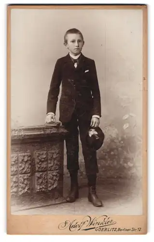 Fotografie Adolf Winkler, Görlitz, Berliner-Strasse 12, Knabe im Anzug mit Hut in der Hand