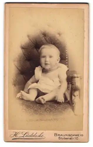 Fotografie H. Lüddecke, Braunschweig, Stobenstrasse 10, Baby im Strampelkleidchen auf einem Sessel