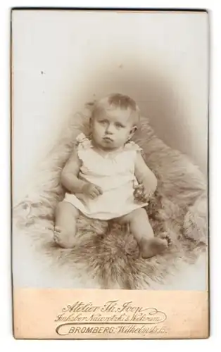 Fotografie Theodor Joop, Bromberg, Wilhelm-Strasse 15, Baby in Strampelkleidchen auf einem Fell