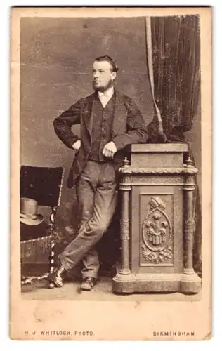 Fotografie H. J. Whitlock, Birmingham, Eleganter Herr mit Seemannsbart lehnt an einem Möbel