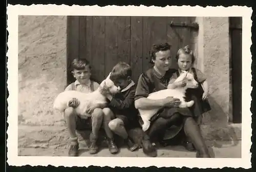 Fotografie Mädchen & Knaben schmusen mit Ziegen - Zicklein auf einem Bauernhof