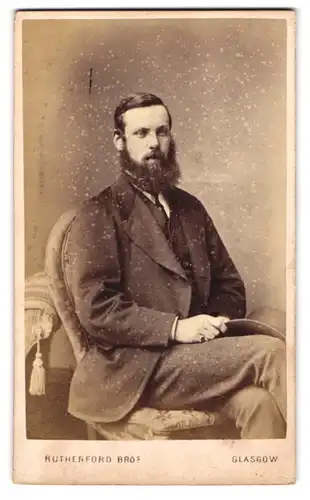 Fotografie Rutherford Bro., Glasgow, 152. Wellington Street, Sitzender Mann mit Hut und Vollbart