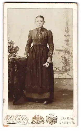 Fotografie H. O. Klein, Lahr i. B., Stehende Dame im Gewand mit Blumen in der Hand