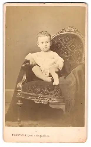 Fotografie Paul Berthier, Paris, Quai Malaquais 15, Kleinkind auf prunkvollem Stuhl mit Decke
