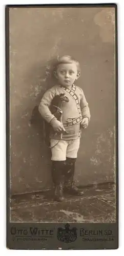 Fotografie Otto Witte, Berlin-SO, Skalitzerstr. 54, Kleiner Junge in modischer Kleidung mit Spielzeugpferd