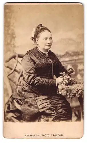 Fotografie W. H. Mason, Croydon, 21. George Street, Gestandene Frau im gerüschten Kleid mit Rose in der Hand