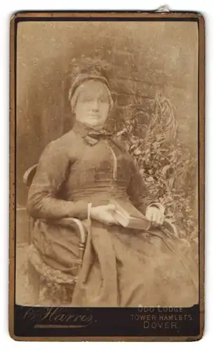 Fotografie C. Harris, Dover, Ältere Dame im Kleid mit Haube und Buch