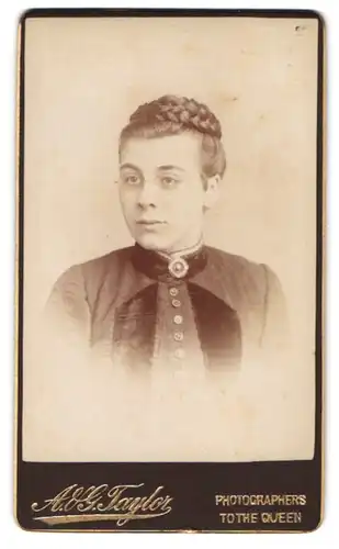Fotografie A. & G. Taylor, Ort unbekannt, Portrait junge Dame mit Flechtfrisur & Brille