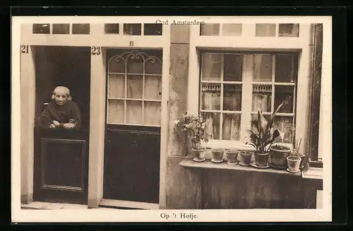 AK Amsterdam, alte Frau schaut aus dem Haus heraus
