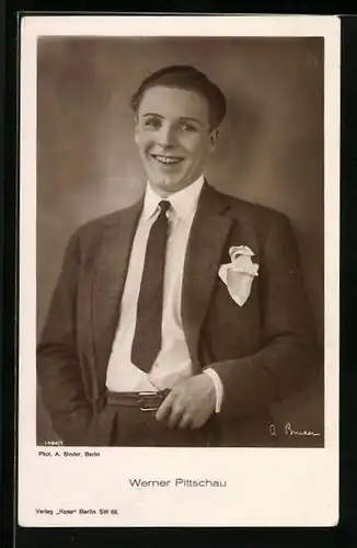 AK Schauspieler Werner Pittschau im Anzug lächelnd an einer Wand stehend