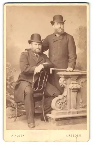 Fotografie A. Adler, Dresden, zwei Herren in dunklen Anzügen mit Melone und Vollbart