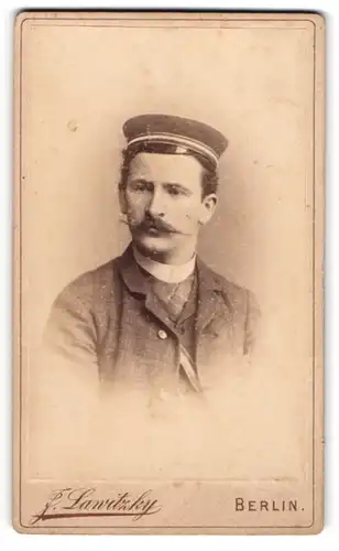 Fotografie F. Lawitzky, Berlin, Student im karierten Anzug mit Tellermütze und Couleur, Zwirbelbart