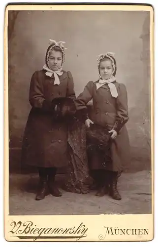Fotografie V. Bieganonsky, München, Klenzerstr. 28, zwei junge Mädchen in Mänteln mit Hauben und Muff
