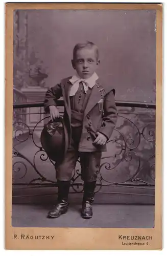 Fotografie R. Ragutzky, Kreuznach, Louisenstr. 6, junger Knabe im Anzug mit Hut posiert im Atelier