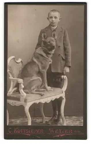 Fotografie C. Kottsieper, Wetter / Ruhr, junger Knabe im Anzug mit seinem Hund auf der Bank