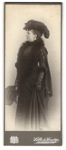 Fotografie Selle & Kuntze, Potsdam, Schwertfegerstr. 14, Portrait Dame im dunklen Kleid mit Federboa und Hut, Fächer