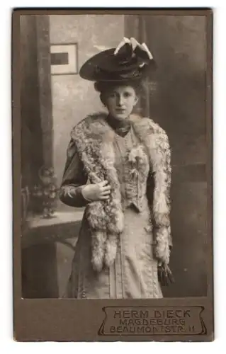 Fotografie Herm. Dieck, Magdeburg, Beaumontstr. 11, Portrait junge Dame in grauen Kleid mit Pelzstola und Hut