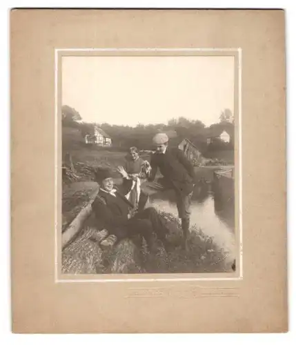 Fotografie Arthur Marx, Frankfurt Main, junger Mann zeigt älterem Herrn eine Schlange am Ufer