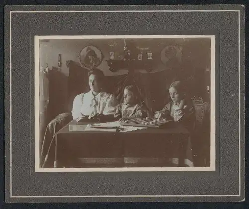 Fotografie unbekannter Fotograf und Ort, Mutter mit ihren beiden Töchtern in der Wohnstube, Dame Brett, Interior