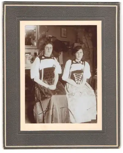 Fotografie unbekannter Fotograf und Ort, zwei junge Damen in Trachtenkleidern posieren im Atelier