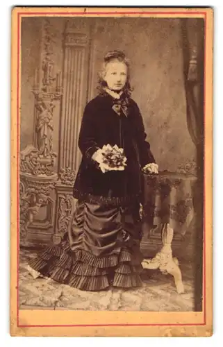 Fotografie W. Loesfin, Grimmen, Dame mit Zierschleife und Blumenstrauss in zeitgenössischem Kleid