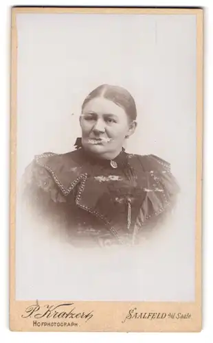 Fotografie P. Kratzert, Saalfeld /Saale, Gestandene Frau im hochwertigen Rüschenkleid mit Brosche am Kragen