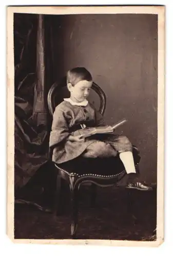 Fotografie unbekannter Fotograf und Ort, Kleiner Bursche im zeitgenössischen Kostüm ein Buch lesend