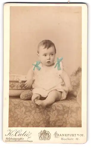 Fotografie Katharina Culié, Frankfurt a. M., Hochstrasse 32, Kleinkind im Kleid auf Recamiere sitzend