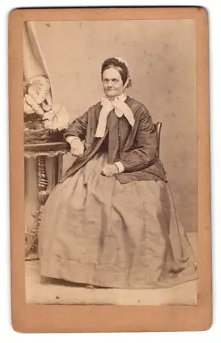 Fotografie Emil Luban, Görlitz, Portrait ältere Frau Klette im schlichten Kleid mit Jacke und Haube