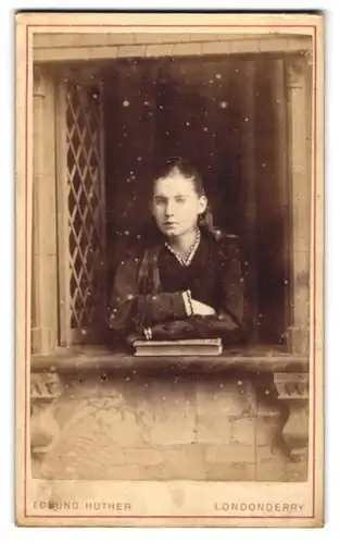 Fotografie Edmund Huther, Londonderry, Carlisle Road, Mädchen mit Buch in einer Studiokulisse