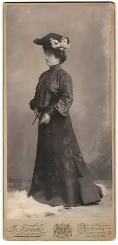 Fotografie J. Fuchs, Berlin, Frau Dora im dunklen verzierten Kleid mit Hut und Lesebrille, 1905