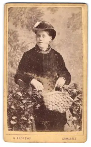 Fotografie H. Andrews, Carlisle, Lowther Street, Modisch gekleidete Dame mit Korbtasche