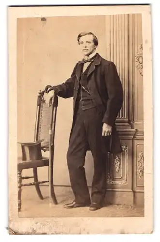 Fotografie Ph. v. Franz Purkholzer, Wien, Portrait österreichischer Herr im Anzug mit Fliege und Zylinder auf dem Stuhl