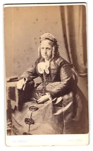 Fotografie Whiteman, Hastings, Portrait ältere Engländerin im Biedermeierkleid mit Haube und Korkenzieherlocken