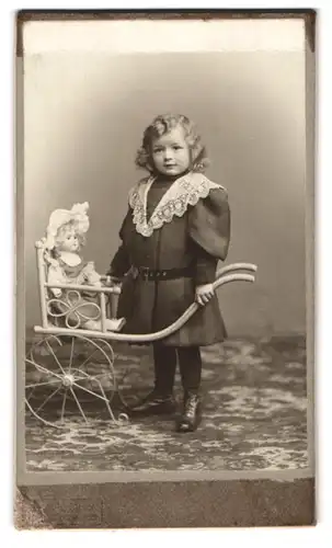 Fotografie unbekannter Fotograf und Ort, kleines Mädchen im Kleid mit Puppenwagen und grosser Puppe, Locken