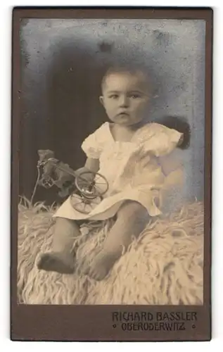 Fotografie Richard Bassler, Oberoderwitz, Portrait kleines Kind sitzt auf Fell mit Spielzeugbär in der Hand