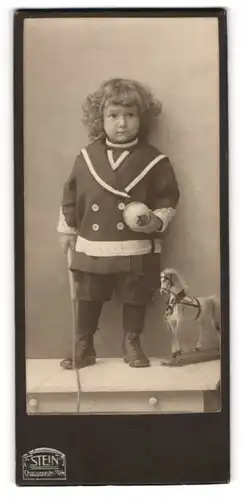 Fotografie F. Stein, Berlin, Chausseestr. 70 /71, kleines Kind im Kleidchen mit Spielzuegpferd und Peitsche